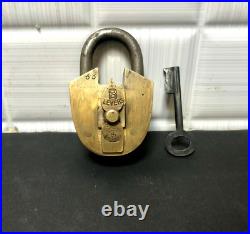 An Old Vintage Brass Unique Clock Hand Style Peg Padlock With Key